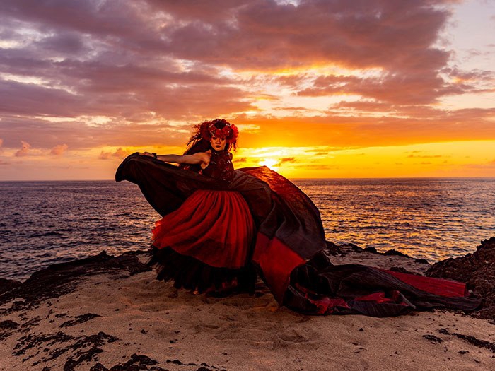 Feast and Fire Luau dancer beside the Kona ocean at sunset